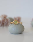 Front view of minimalist gold wire wrapped peridot ring — faceted 5mm olive green peridot bead in warm gold finish, dainty handcrafted August birthstone crystal ring for women