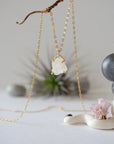 Close-up front view of minimalist rainbow moonstone necklace for women, natural raw moonstone in 14k gold vermeil prong setting on gold filled chain (June birthstone).