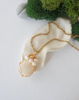 Moonstone and freshwater pearl pendant on gold plated brass chain laying flat, handmade wire wrapped jewelry for women
