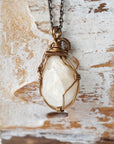 Back view of antique bronze wire wrapped moonstone pendant, showing handcrafted wrapping details and secure setting.