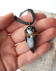 Black obsidian arrowhead necklace for men with antique bronze copper wire wrap, shown in hand for size reference, by Designs by Nature Gems.