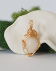 Back angle detail of opal and freshwater pearl pendant, showing wire wrapping and natural stone
