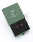 Peridot drop earrings presented in a branded gift box, ready for gifting, with antique bronze copper wire wrapping.