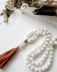 Close-up of natural 8mm rainbow moonstone and moonstone beads on hand knotted mala necklace, June birthstone meditation beads.