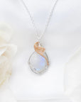 Close-up of natural rainbow moonstone cabochon necklace with sterling silver and 14k gold filled artisan wire wrapping (June birthstone).