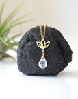 Close-up of rainbow moonstone and lotus necklace for women, faceted pear rainbow moonstone drop with gold vermeil lotus charm on 14k gold filled chain (June birthstone).