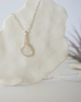 Right side angle close-up showing artisan soft silver wire wrapping around an 8mm rainbow moonstone bead on minimalist June birthstone necklace.
