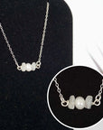 Close-up of raw rainbow moonstone stones and freshwater pearl bar on 925 sterling silver necklace
