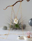 Back view of raw rainbow moonstone pendant showing gold vermeil prong setting and bail on minimalist rainbow moonstone necklace for women.