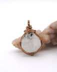 Front angle view of natural rainbow moonstone pendant with artisan antique bronze copper wire wrapping for all genders