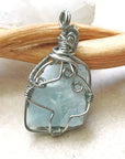 Back view of raw aquamarine pendant, genuine stone with handcrafted dark silver wire