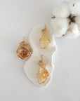 Three raw citrine pendants in 14k gold filled, showing natural variation in size, shape, and color. Handcrafted November birthstone jewelry by Designs by Nature Gems.