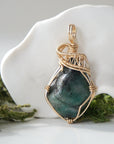 Front view of natural polished-raw emerald pendant with detailed artisan wire wrapping in 14k gold-filled wire.