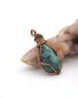 Right angle view of raw emerald pendant showing handcrafted antique bronze copper wire wrapping detail.
