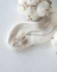 Detailed view of raw Herkimer diamond pendant on 925 sterling silver chain for women with handmade artisan wrapping.