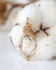 Detailed view of raw Herkimer diamond pendant with artisan wire wrapping in warm gold copper for women.