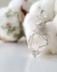 Left angle view of raw Herkimer diamond necklace for women highlighting artisan wire wrapping in 925 sterling silver.