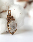 Right angle view of handmade Herkimer diamond pendant for women showing antique bronze copper wire artistry.