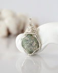Back view of raw peridot wire wrapped pendant — silver finish hand-wrapped setting shows craftsmanship and secure stone hold, handmade in Toronto Canada