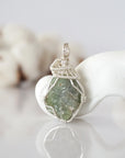 Front view of raw peridot pendant — natural unpolished green peridot stone hand-wrapped in detailed silver finish wire, handcrafted artisan crystal jewelry