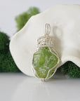 Left side detail of handmade raw peridot necklace — artisan wire wrapped 925 sterling silver pendant, natural peridot stone, ethically sourced crystal jewelry