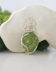 Right side detail of raw peridot crystal pendant — intricate 925 sterling silver wire weaving technique, handcrafted artisan wire wrapped jewelry, Designs by Nature Gems