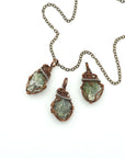 Three raw peridot pendants for women showing natural variation in size, shape, and olive green colour — handcrafted two-tone wire wrapped August birthstone necklaces