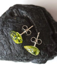 Top angle view of raw peridot stud earrings showing natural stone surface and light-catching translucency — 925 sterling silver stud earrings, August birthstone crystal jewelry