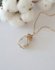 Raw rainbow moonstone necklace in 14k gold filled laying flat. Handcrafted June birthstone jewelry for women by Designs by Nature Gems.
