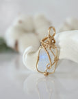 Side view of raw rainbow moonstone pendant in 14k gold filled, showing artisan wire wrapping. Handcrafted June birthstone necklace by Designs by Nature Gems.