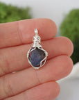 Simple raw sapphire pendant shown in hand for size reference