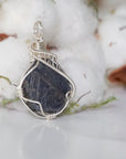 Right-angle detail of women's raw sapphire pendant showing artisan wire-wrapping in bright 925 sterling silver — handcrafted crystal necklace