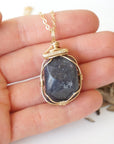 Raw sapphire pendant held in hand to show size — 14k gold-filled wire wrap, women's handcrafted crystal necklace by Designs by Nature Gems