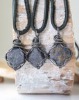 Three raw sapphire pendants showing natural variation in size, shape, and depth of colour — each men's antiqued sterling silver wire-wrapped necklace is individually handcrafted and one of a kind
