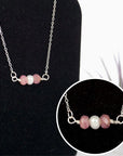 Close-up of raw ruby stones and freshwater pearl bar on 925 sterling silver necklace