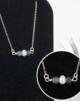 Close-up of raw sapphire stones and freshwater pearl bar on 925 sterling silver necklace