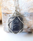 Back view of natural sapphire pendant showing the detail of dark silver wire-wrapping — white gold chain, one-of-a-kind handcrafted crystal jewelry