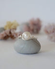 Front view of a minimalist pearl wire wrapped ring featuring a natural freshwater pearl