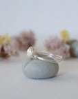 Side view of a sterling silver pearl wire wrapped ring showing minimalist craftsmanship