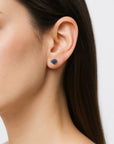 Woman wearing natural raw sapphire stud earrings with 925 sterling silver posts — handcrafted September birthstone jewelry