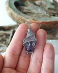 Women’s raw amethyst pendant necklace shown in hand for size reference, white gold plated copper wire wrap