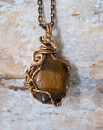 Back view of yellow tiger's eye pendant — bronze and gold wire wrapping detail, one of a kind handmade crystal pendant