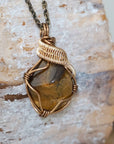 Right side view of yellow tiger's eye pendant — bronze and gold wire wrapping detail, handmade Gemini zodiac crystal necklace