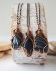 Three blue tiger's eye necklaces for men – showing natural variation in size, shape, and shade of blue, antique bronze copper wire wrapping.
