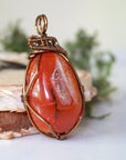 Right angle close-up of carnelian necklace – highlighting unique wire-wrapped artistry, raw carnelian, gender-inclusive jewelry.