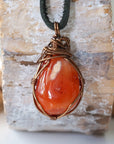 Back view of handcrafted men's carnelian necklace – natural stone and wire wrapping, Virgo birthstone, black leather cord.