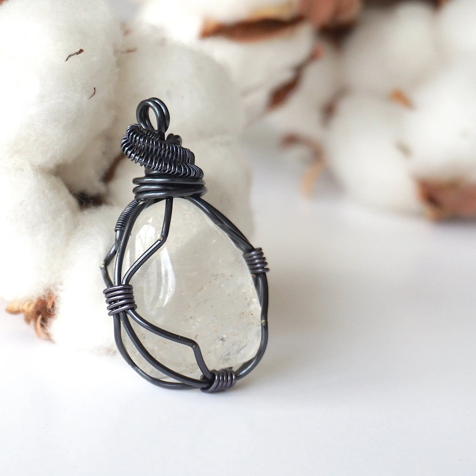 Right angle close-up of clear quartz pendant – showcasing artisan wire wrapped gunmetal copper, natural crystal.