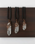 Three clear quartz point necklaces for men – showing natural variation in size, shape, antique bronze copper wire wrapping.