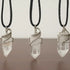 Three clear quartz point necklaces for men – showing natural variation in size, shape, white gold copper wire wrapping.