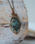 Right angle close-up of emerald necklace – detailed artisan wire wrapping in bronze and silver copper, handcrafted May birthstone pendant.